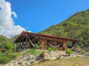 a house with a hammock in front of a mountain at Chácara Morro da Pedra in Cavalcante