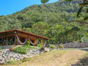 a house with a mountain in the background at Chácara Morro da Pedra in Cavalcante