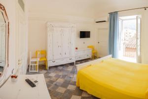 - une chambre avec un lit jaune et une commode dans l'établissement Casa don Luigi, à Cefalù