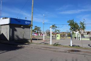 una calle vacía con un estacionamiento con un edificio en Monoambiente para 2 personas en Neuquen en Neuquén