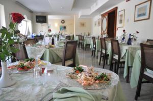 a dining room with tables and chairs with plates of food at Hotel Jollino in Pineto