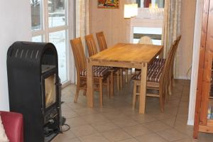 a dining room with a table and chairs and a stove at Strandhaus Deichkrone in Baabe