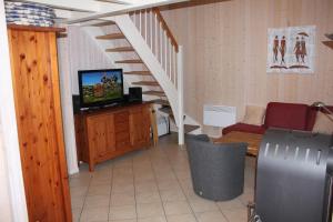 ein Wohnzimmer mit einem TV und einer Treppe in der Unterkunft Strandhaus Deichkrone in Baabe