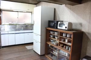 una cucina con frigorifero bianco e forno a microonde di Tsukubo-gun - House / Vacation STAY 34603 a Hayashima
