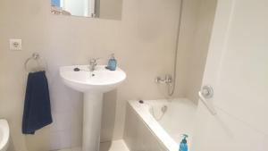 a white bathroom with a sink and a bath tub at Pis Firalet - Olot in Olot