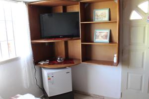 uma cozinha com uma televisão e um frigorífico num quarto em Monoambiente para 2 personas en Neuquen em Neuquén