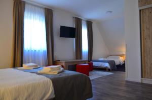 a hotel room with two beds and a television at Natura Plitvice Lakes in Plitvička Jezera +30 photos