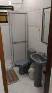 a bathroom with a toilet and a sink at Casa Temporada Ubatuba in Ubatuba