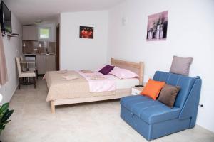 a bedroom with a bed and a blue chair at Apartments Nino Skadar lake in Virpazar