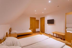 a bedroom with two beds and a tv on the wall at Vila Slavica in Zlatibor