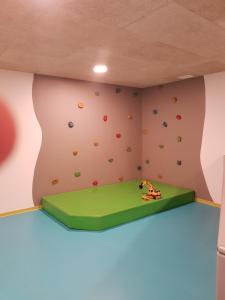 una parete da arrampicata in una stanza per bambini con parete di roccia di Hotel Restaurant Schaurhof a Vipiteno
