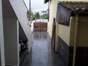 an alley with a gate and a tiled floor at Casa Temporada Ubatuba in Ubatuba