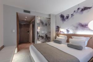 1 dormitorio con 1 cama blanca grande y 2 almohadas en Le Grand Balcon Hotel, en Toulouse