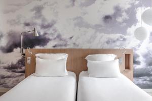 two beds in a room with a wall mural at Le Grand Balcon Hotel in Toulouse