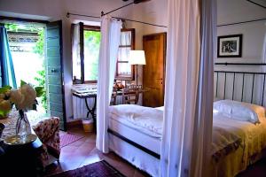 a bedroom with a bed and a desk and a window at Le Traverse in Pienza
