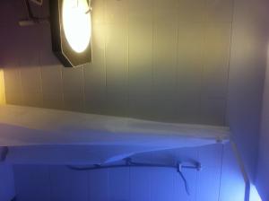 a bathroom with a tub with a light on the wall at Panca Dewi Guest House in Yogyakarta +16 photos