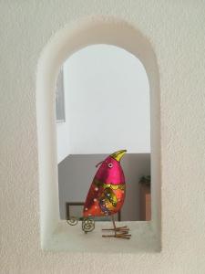 Un oiseau coloré est assis sur un rebord de fenêtre dans l'établissement Casa Olivo, à Montagnola
