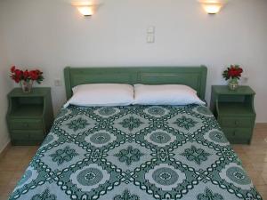 HOTEL KAPARI في أغيا أنا ناكسوس: غرفة نوم بسرير اخضر مع مواقف ليلتين