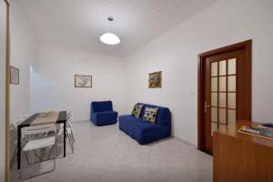 ein Wohnzimmer mit einem blauen Sofa und einem Tisch in der Unterkunft Trimarchi House in Neapel