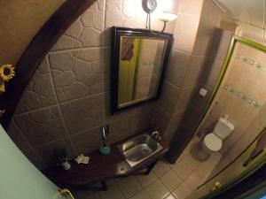 La salle de bains est pourvue d'un lavabo, d'un miroir et de toilettes. dans l'établissement Apartament w Kamienicy, à Biskupiec