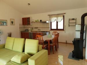 a living room with a couch and a table and a kitchen at Apartment Slavica in Šajini