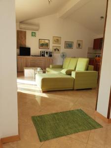 uma sala de estar com um sofá verde e uma televisão em Apartment Slavica em Šajini