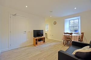 a living room with a couch and a tv and a table at Modern Commercial Street Maisonette in Lerwick