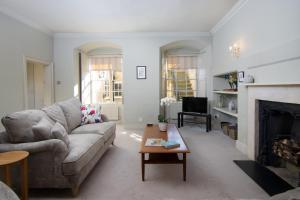 sala de estar con sofá y chimenea en Stunning Royal Crescent Apartment with 3 Bedrooms en Bath