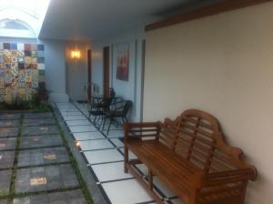 a room with two benches on a patio at Panca Dewi Guest House in Yogyakarta