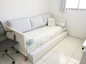 ein Bett mit Kissen und einem Stuhl in einem Zimmer in der Unterkunft Solar Teixeira Residencial in Porto De Galinhas