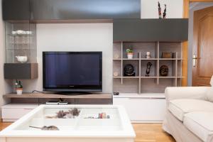 Il comprend un salon doté d'une télévision et d'une table basse blanche. dans l'établissement Apartamento 8 - 10 pax Soria - Centro, à Soria
