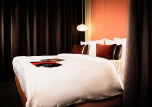 ein großes weißes Bett in einem Hotelzimmer in der Unterkunft JAMS Music Hotel Munich in München + 86 Fotos