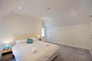 a bedroom with a white bed with two towels on it at Modern Commercial Street Maisonette in Lerwick