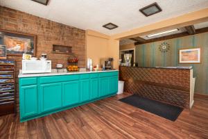 cocina con armarios verdes y microondas en Aikens Lodge, en Kanab