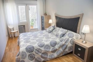 a bedroom with a bed with a blue and white comforter at Apartamento 8 - 10 pax Soria - Centro in Soria