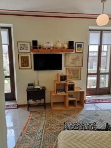 a living room with a tv on the wall at Squisleep in San Daniele del Friuli