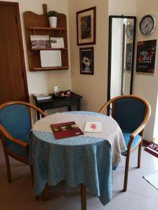 a table with two chairs and a book on it at Squisleep in San Daniele del Friuli