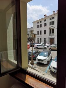 a window with a view of a parking lot with cars at Squisleep in San Daniele del Friuli