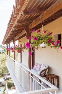 einen Balkon mit rosa Blumen auf einem Haus in der Unterkunft Nikos & Vivi Studios in Perivólion