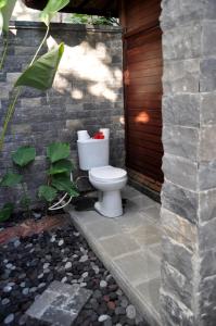 a white toilet sitting outside of a house at Pondok Masa Depan in Sidemen