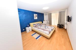 1 dormitorio con cama y pared azul en Apartament Florin, en Mamaia