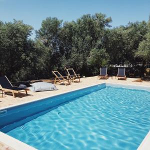 a swimming pool with two chairs and a bed at Villa Gaia in Monemvasia