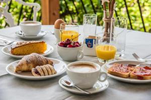 a table with plates of breakfast foods and cups of coffee at Ischia Dream Sunset in Ischia