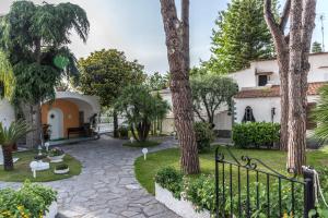 a courtyard with palm trees and a fence at Ischia Dream Sunset in Ischia