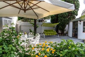 a patio with an umbrella and chairs and flowers at Ischia Dream Sunset in Ischia