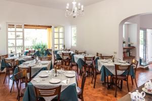 a dining room with tables and chairs and a chandelier at Ischia Dream Sunset in Ischia