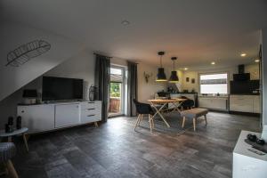 Ferienwohnung Traumblick في Wolfshagen: مطبخ وغرفة معيشة مع طاولة وتلفزيون