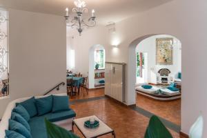 a living room with a blue couch and a dining room at Ischia Dream Sunset in Ischia