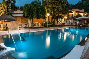 a swimming pool at night with a water fountain at Ischia Dream Sunset in Ischia