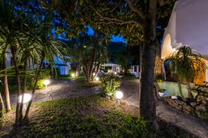 a resort yard with trees and lights at night at Ischia Dream Sunset in Ischia